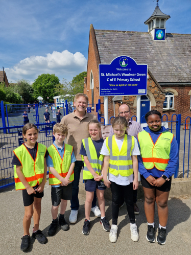 Grant and ambassadors outside the school